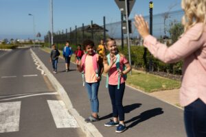 Lehrerin mit Schülern im Straßenverkehr