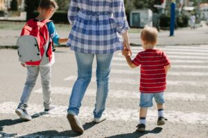 Mutter und Kinder überqueren den Zebrastreifen