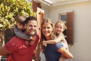 Eltern tragen ihre glücklichen Kinder Huckepack