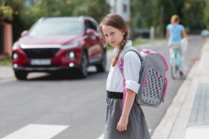 Schülerin wartet am Straßenrand
